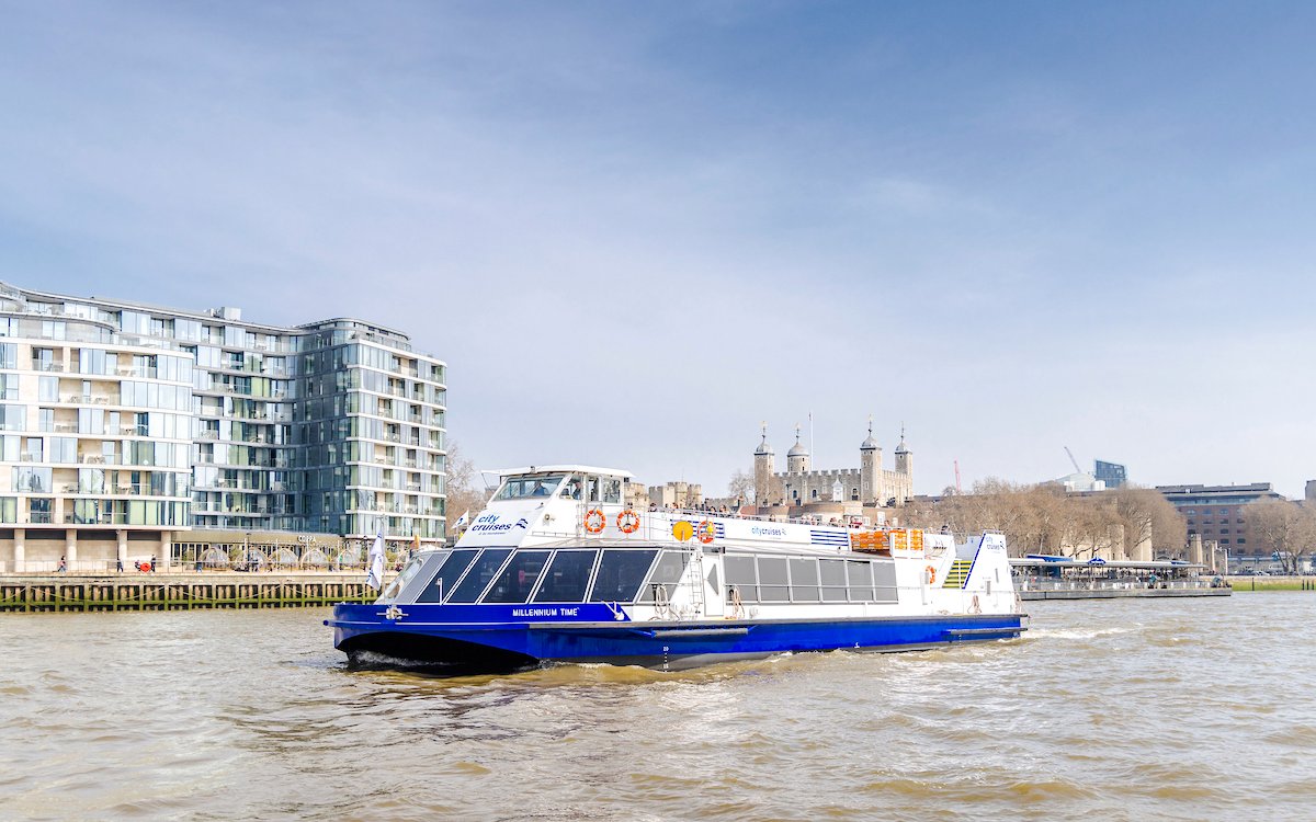 Cruise boat on the Thames River with the Tower of London in the background.