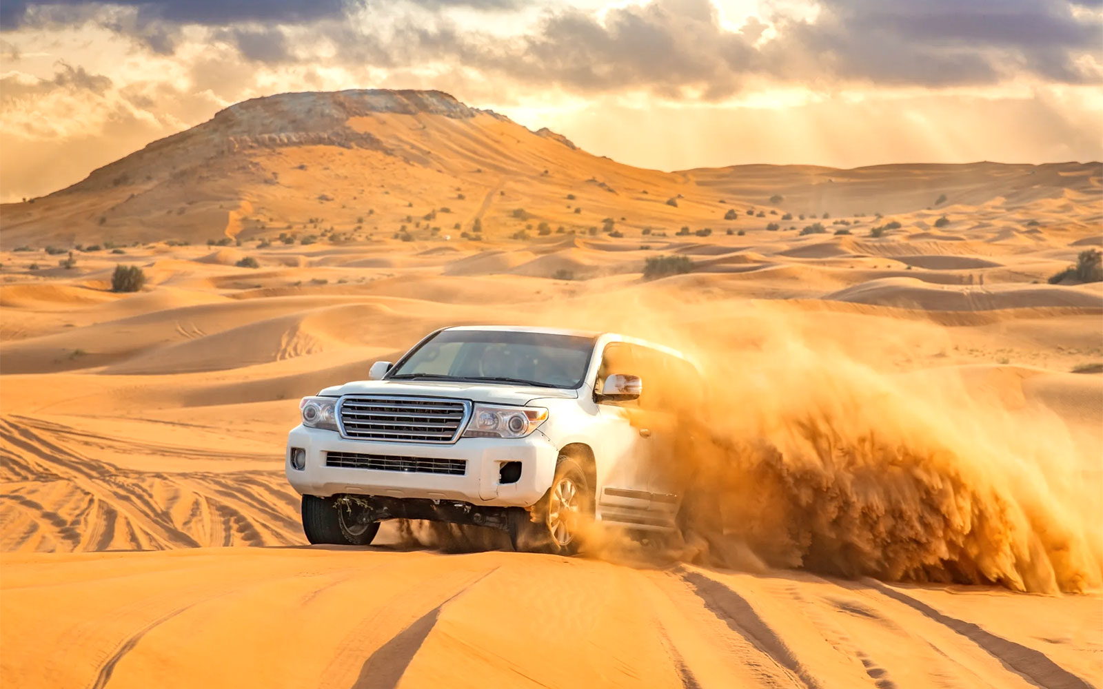 A 4x4 vehicle throws sand as it explores the desert dunes in Dubai.