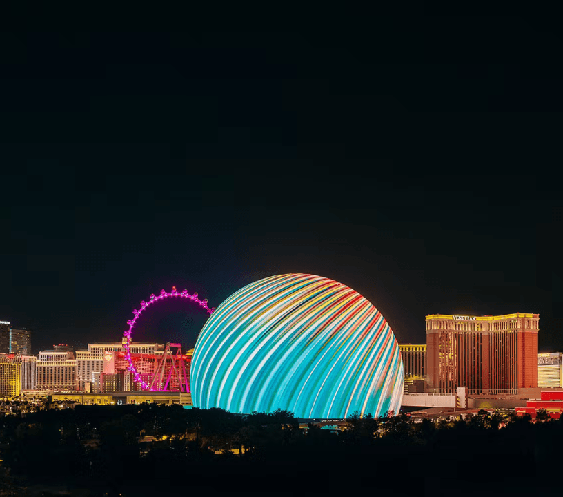 The Sphere stands out as it is lit against the iconic Las Vegas Strip.