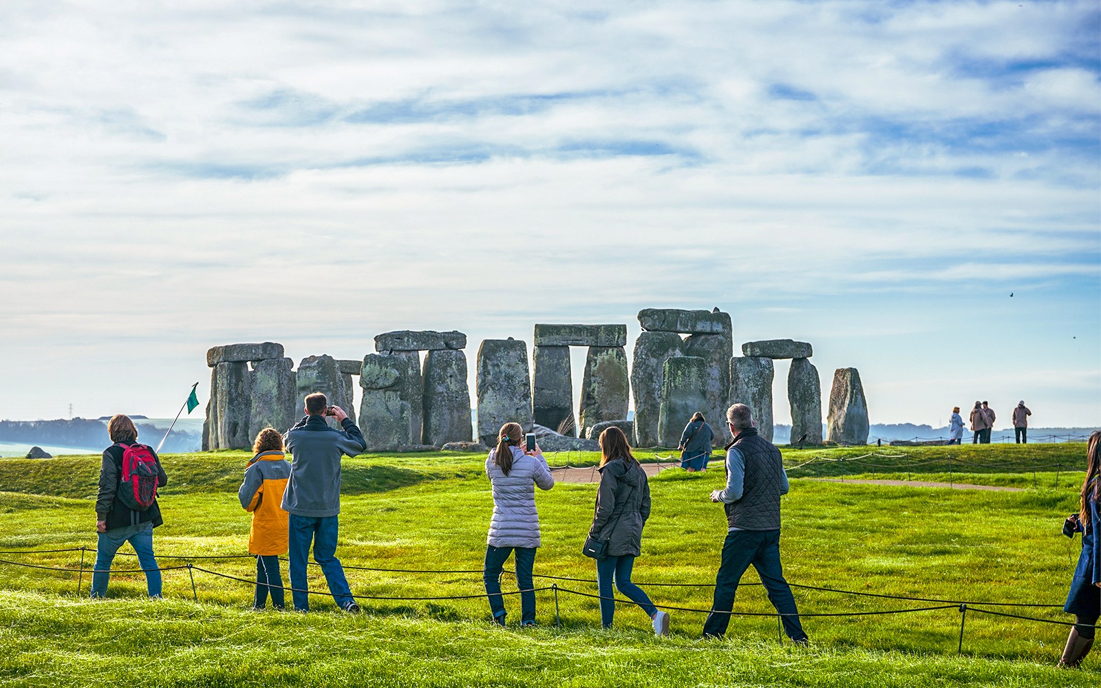 Tourists at Stonehenge, viewing ancient stone structures on a day trip from London.