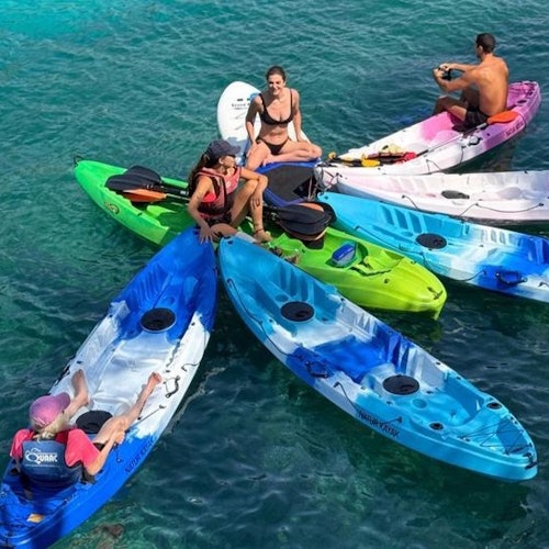 A group of people with their kayaks nose to nose in the Bay of Palma