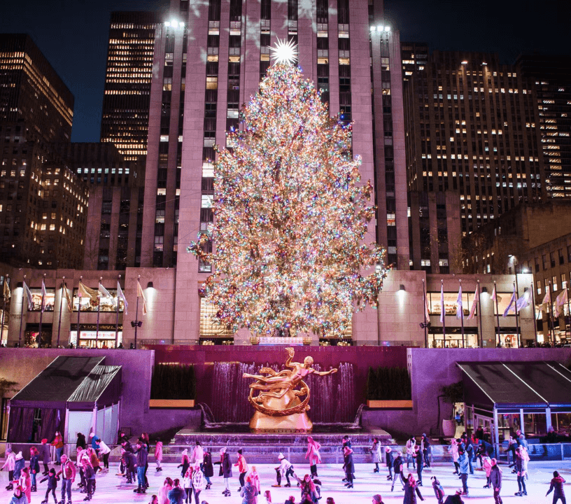 Rockefeller Center Christmas Tree adorned with lights and decorations stands tall above the Rockefeller Center Ice Rink.